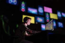 Hands on a controller in front of glowing screens