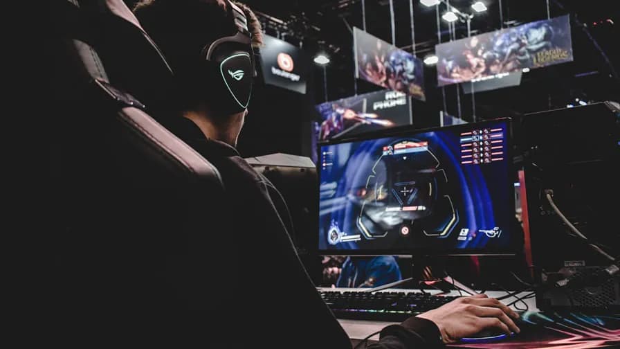 A player with a headset competing at a PC tournament station